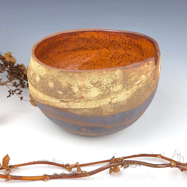 Ceramic bowl with gold interior on a white background