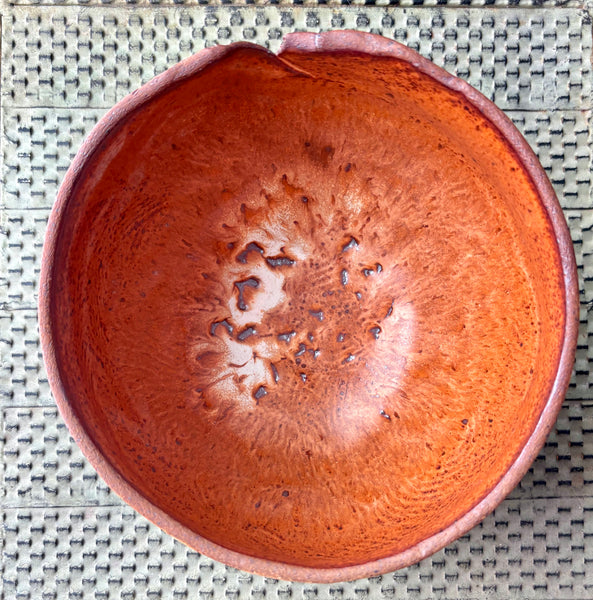 Ceramic bowl with textured surface on a woven mat